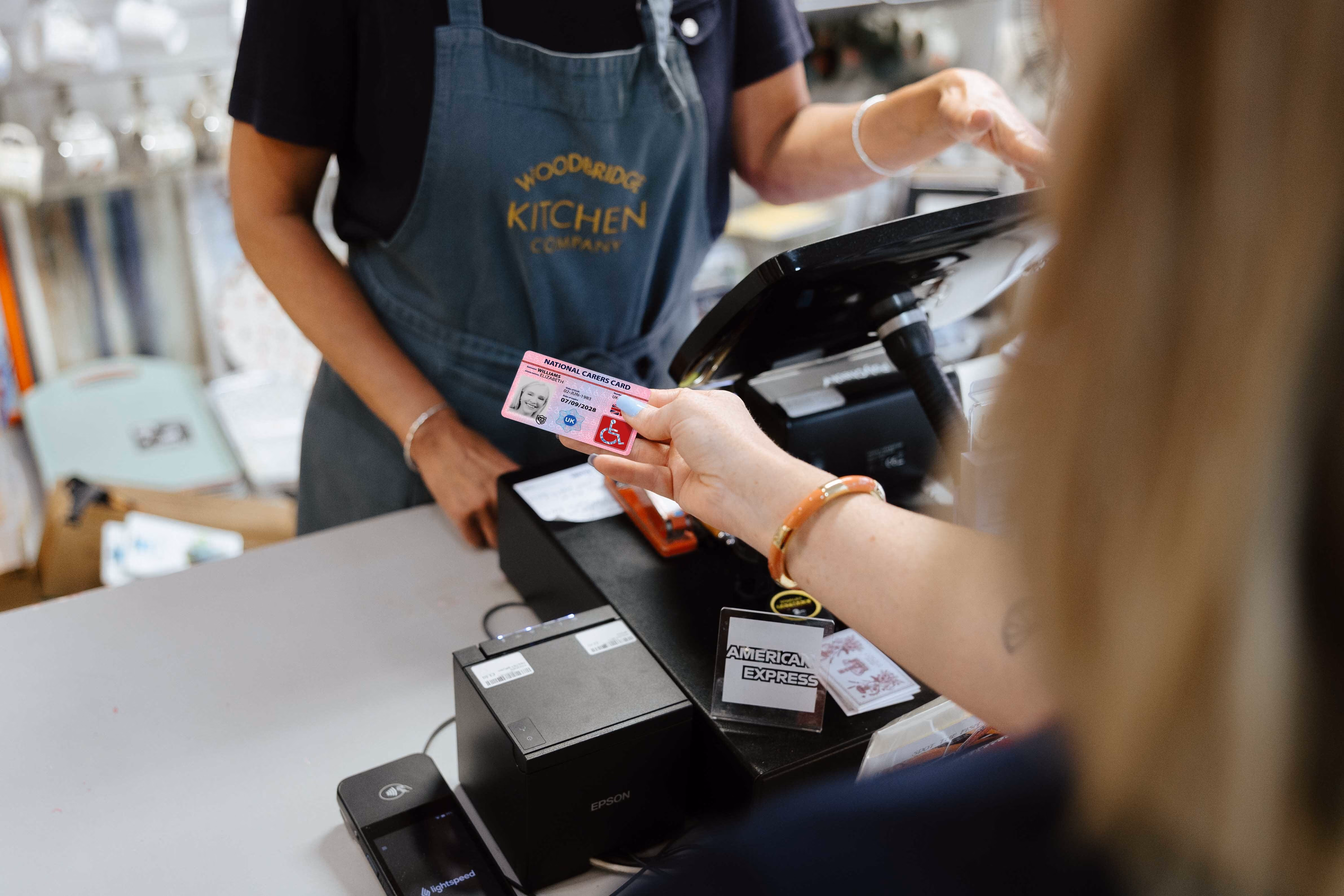 national disability card holder showing her card at a venue for carer ticket access