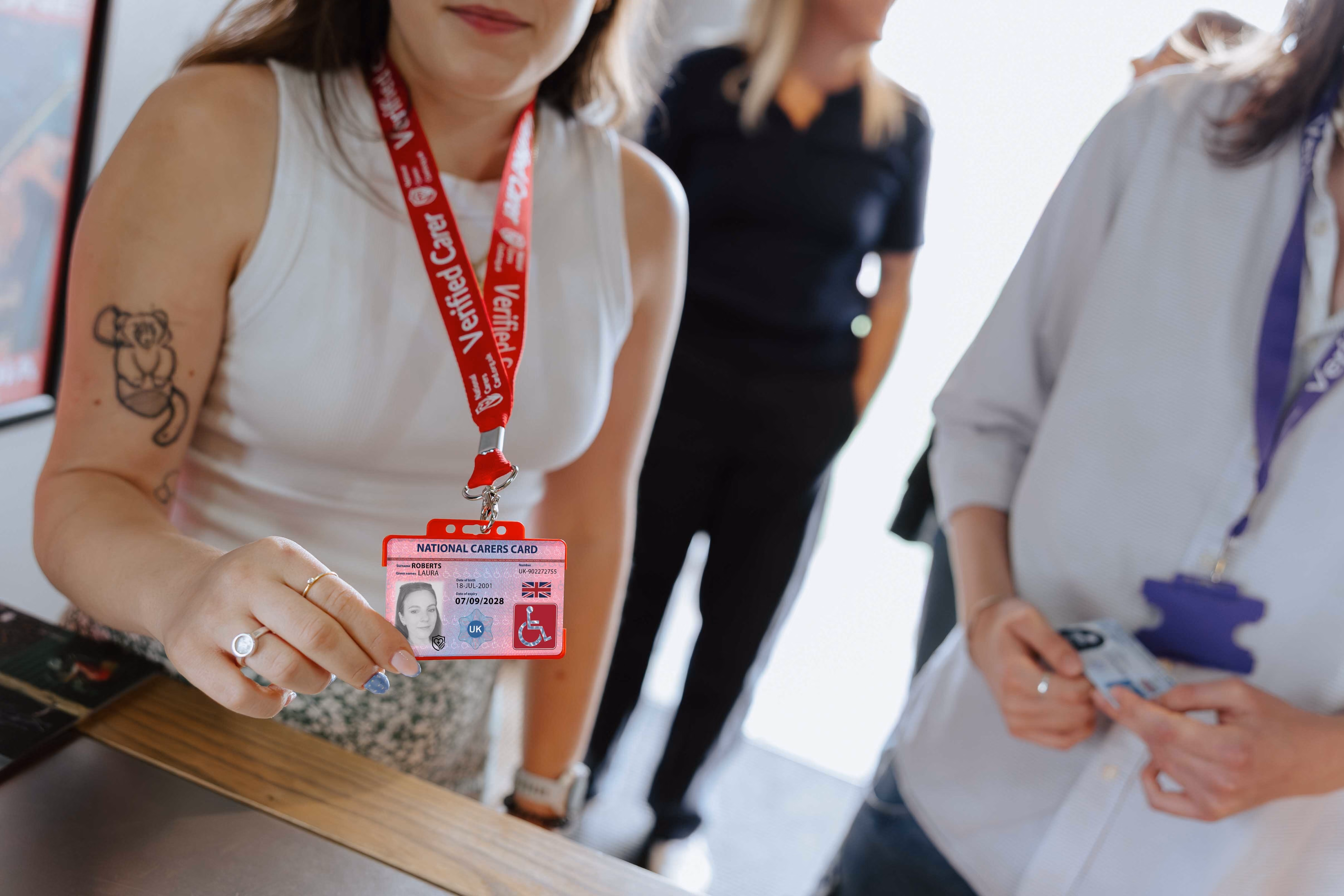 national disability card holder showing her card at a venue for carer ticket access
