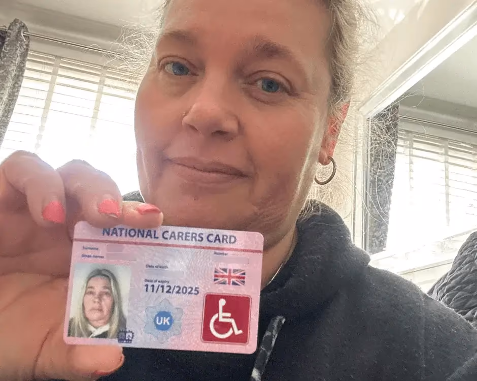 Photo of a National Carers Cardholder holding their carers ID card