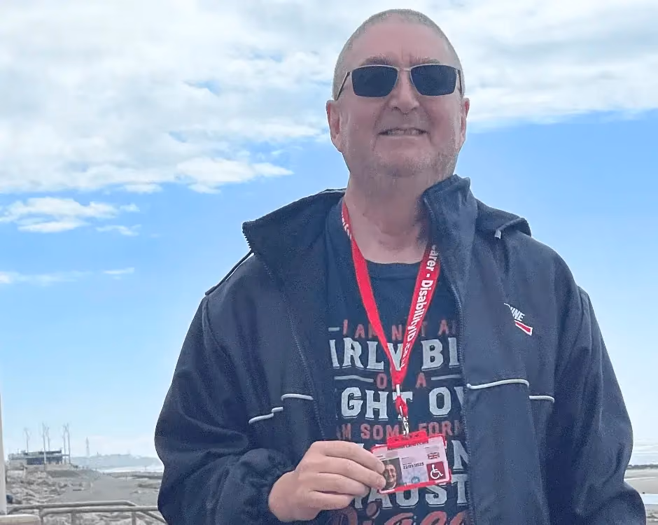 Photo of a National Carers Cardholder holding their carers ID card