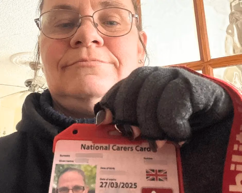 Photo of a National Carers Cardholder holding their carers ID card