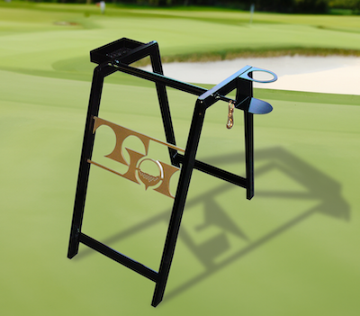 Black metal golf bag stand on a green course, featuring a golf tee holder and logo panel.