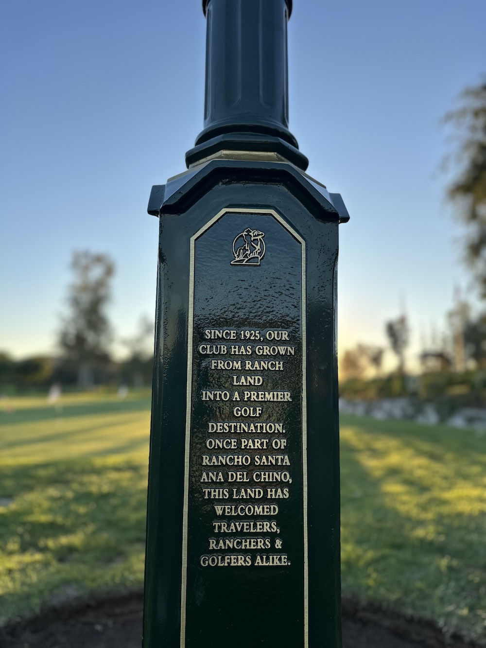 cast bronze memorial plaque on the base of a cast metal golf clock