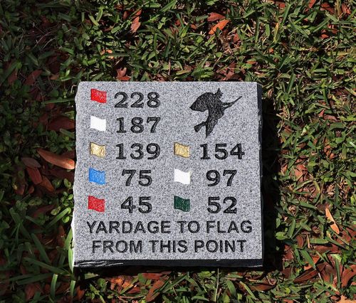 Grey granite golf yardage marker with distances to flags: red 228 and 45 yards, white 187 and 97 yards, gold 139 and 154 yards, blue 75 yards, green 52 yards.