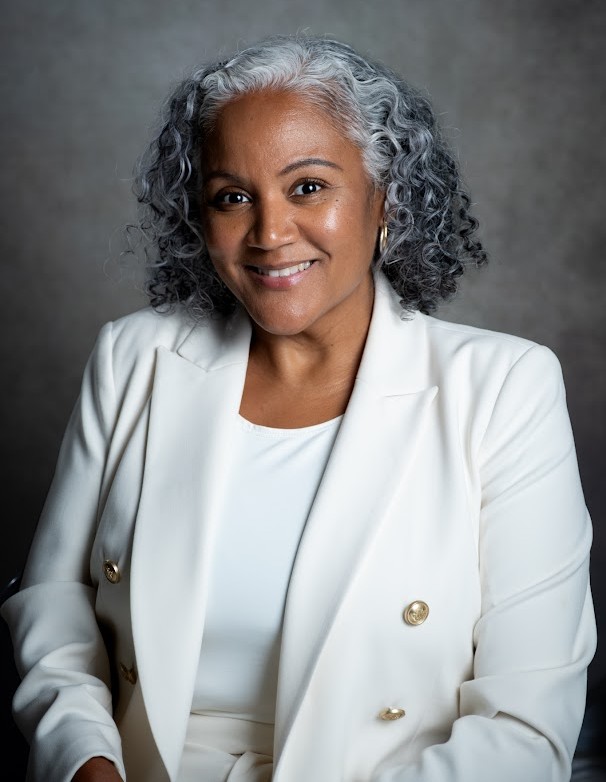 Principal of Riverdale Avenue Community School smiling in white blazer