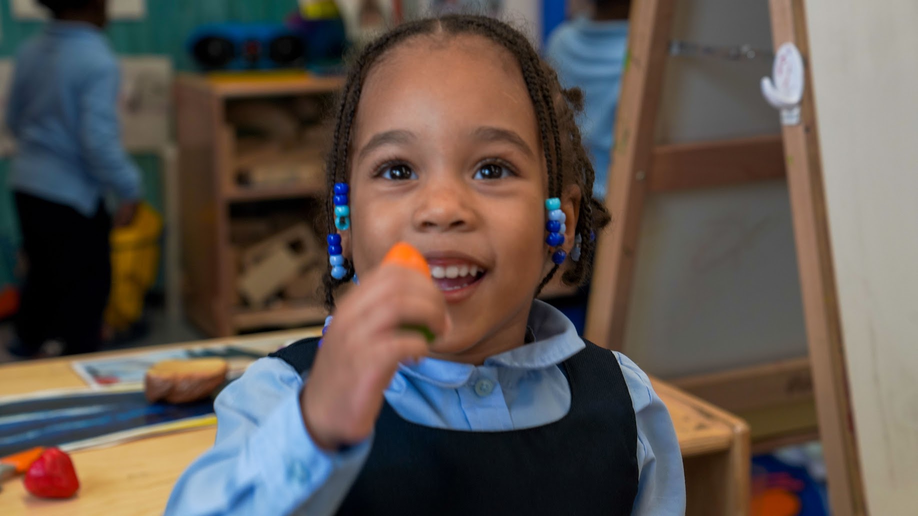 Student smiling while playing with classroom materials