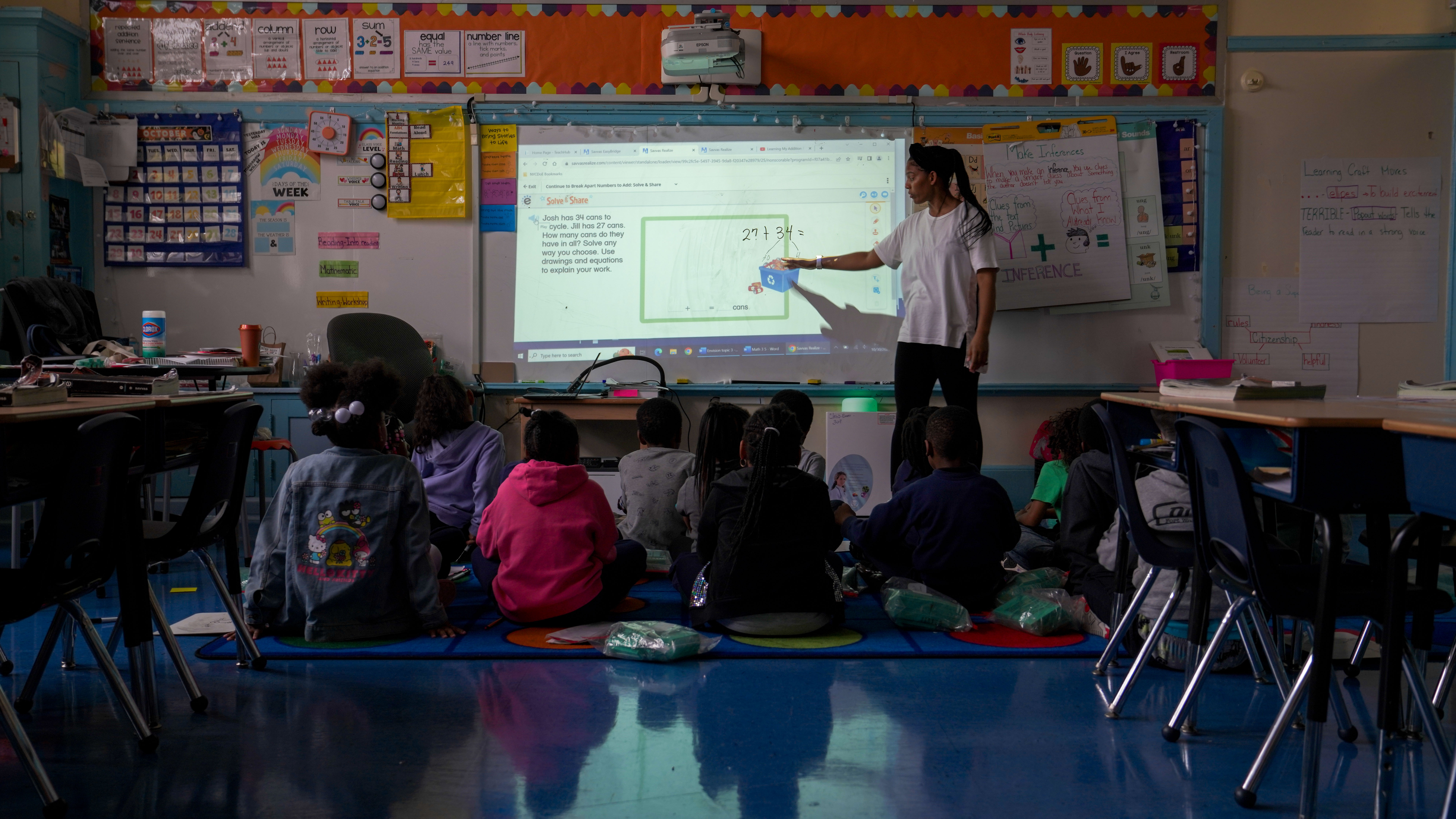 Teacher presenting math lesson to students on interactive whiteboard