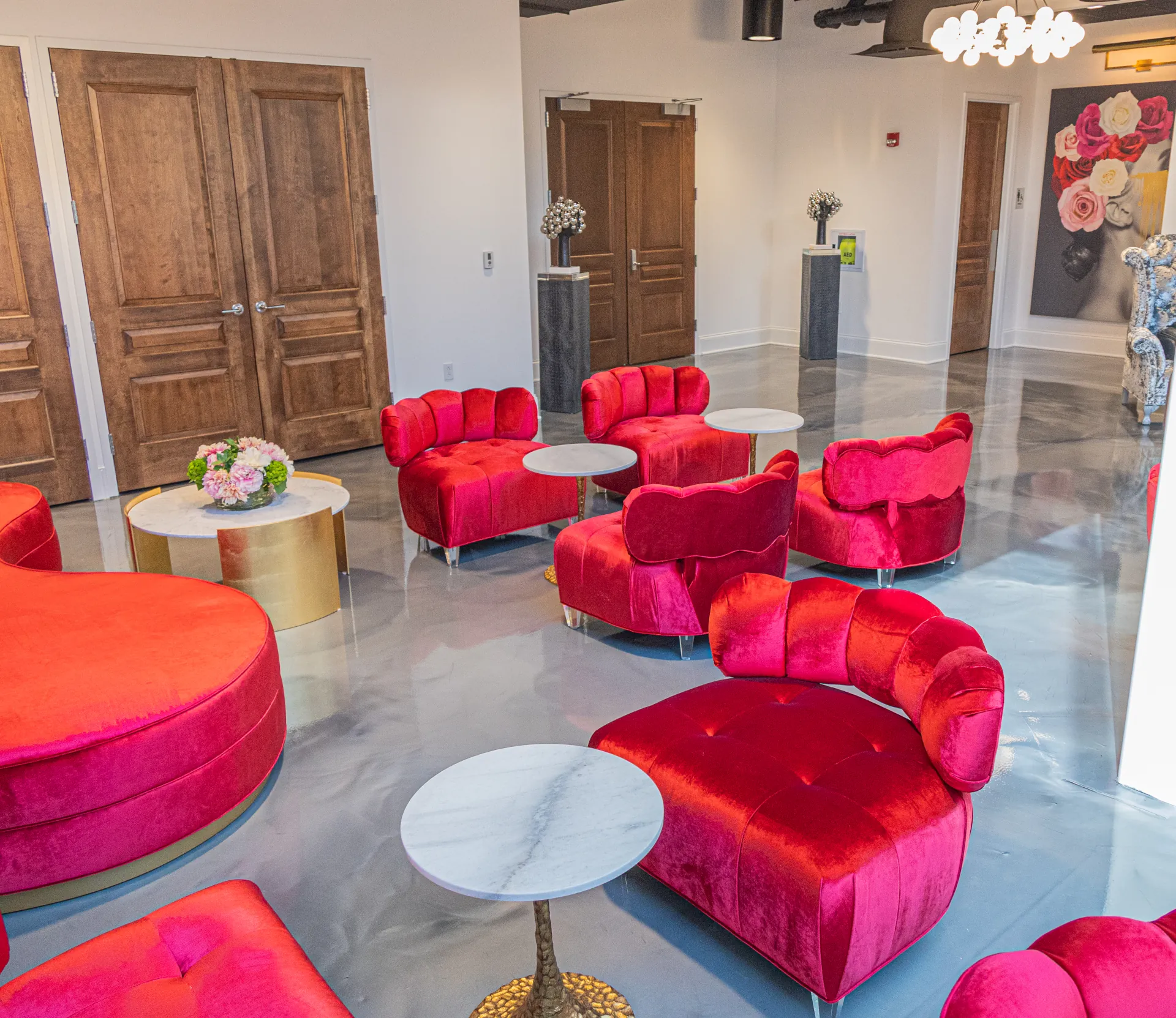 lobby area in the Employer Health building in Canton Ohio. White-grey metallic epoxy flooring with red chairs and white tables