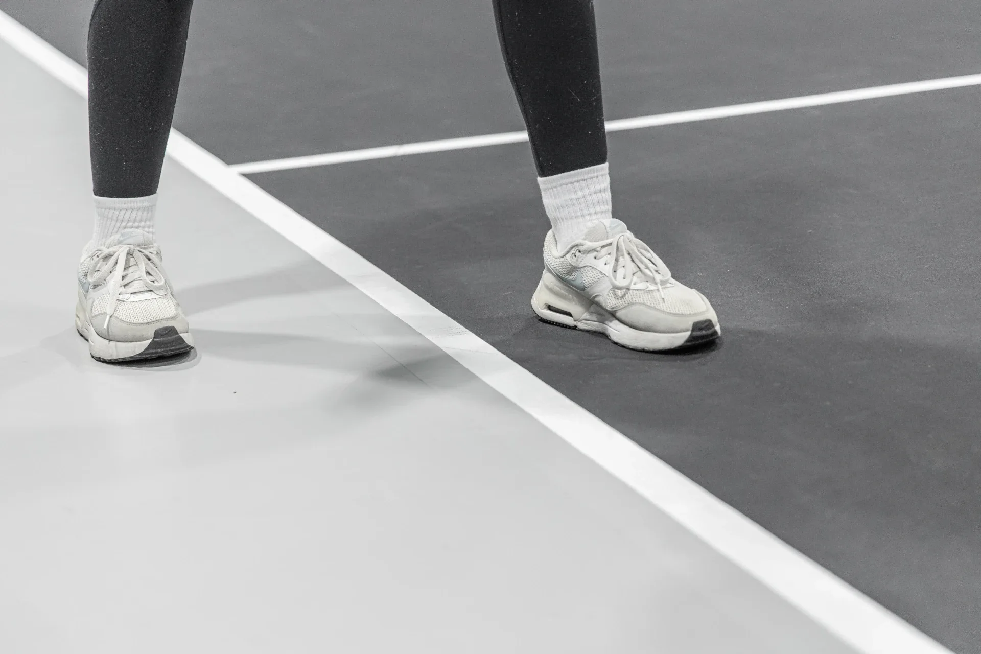 athletic shoes standing on indoor pickleball court