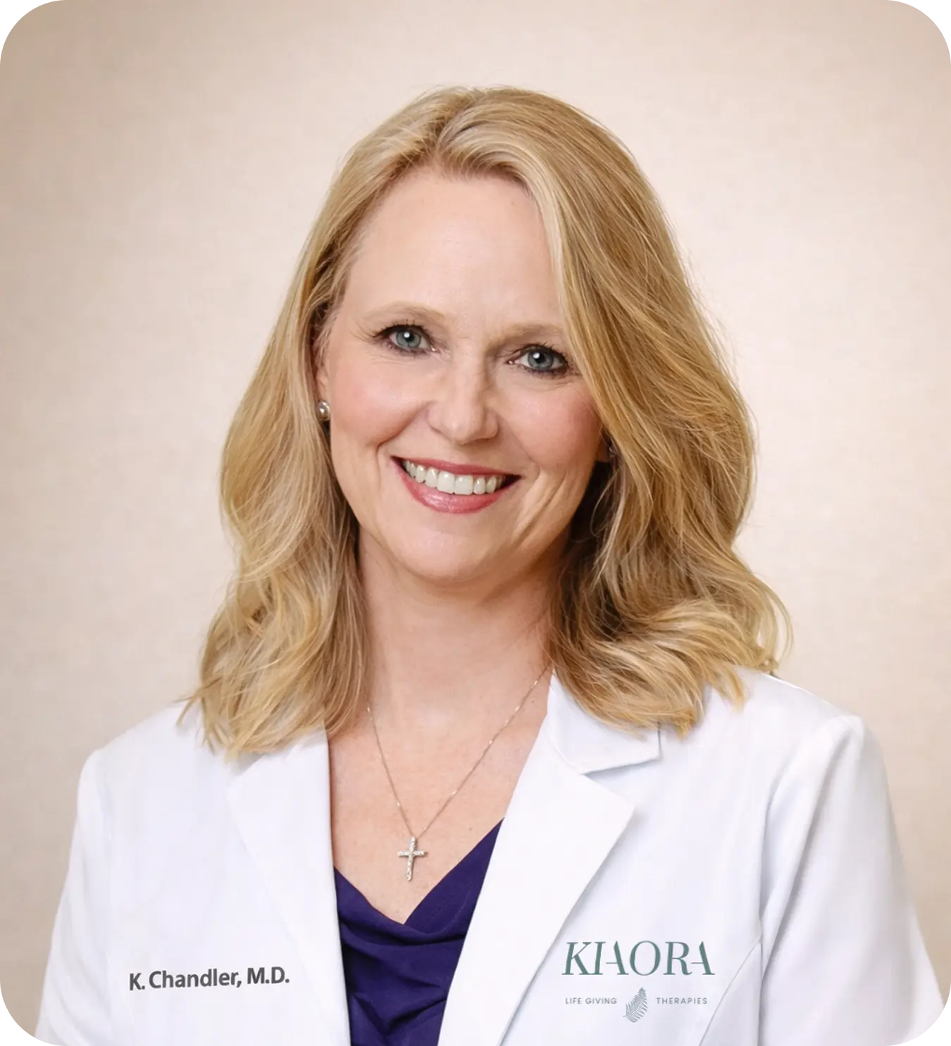 Smiling blonde woman wearing a white medical coat with name K. Chandler, M.D. and Cornerstone Clinic for Women logo.
