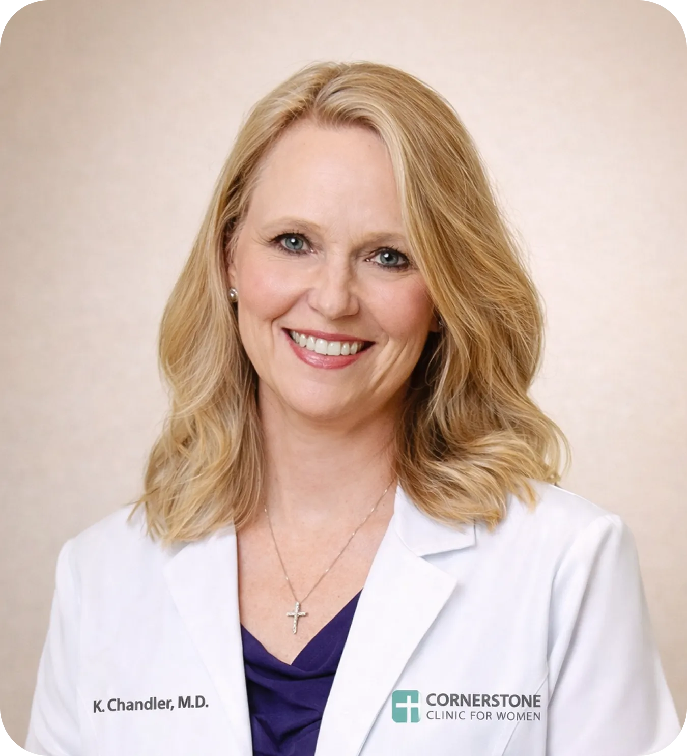 Smiling blonde woman wearing a white medical coat with name K. Chandler, M.D. and Cornerstone Clinic for Women logo.