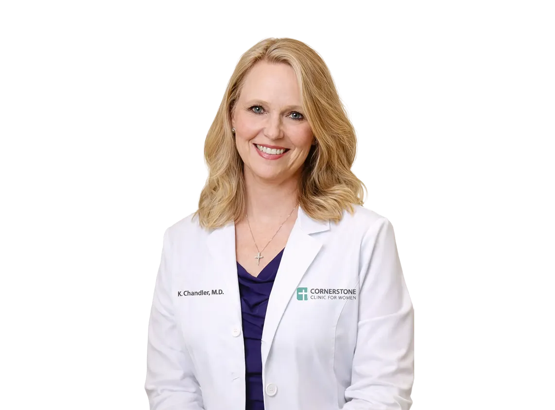 Smiling woman with blonde hair wearing a white medical coat labeled Cornerstone Clinic for Women and name tag K. Chandler, M.D.
