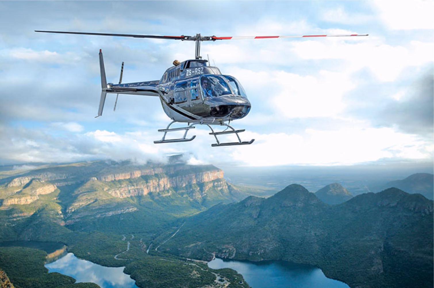 A helicopter flying over the Blyde River Canyon, providing passengers with a panoramic view of the dramatic landscapes and wildlife below.