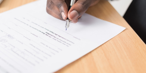 un homme avec un stylo à plume en train de signer un document