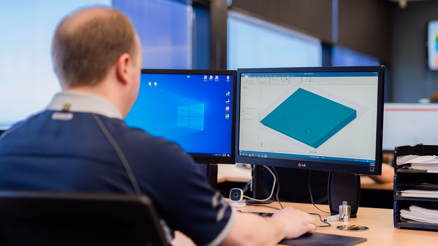Technician viewing water jet cutting system software onto computer screens