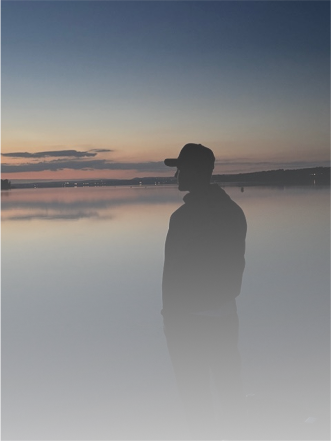 eine Person, die den Sonnenuntergang am Strand beobachtet