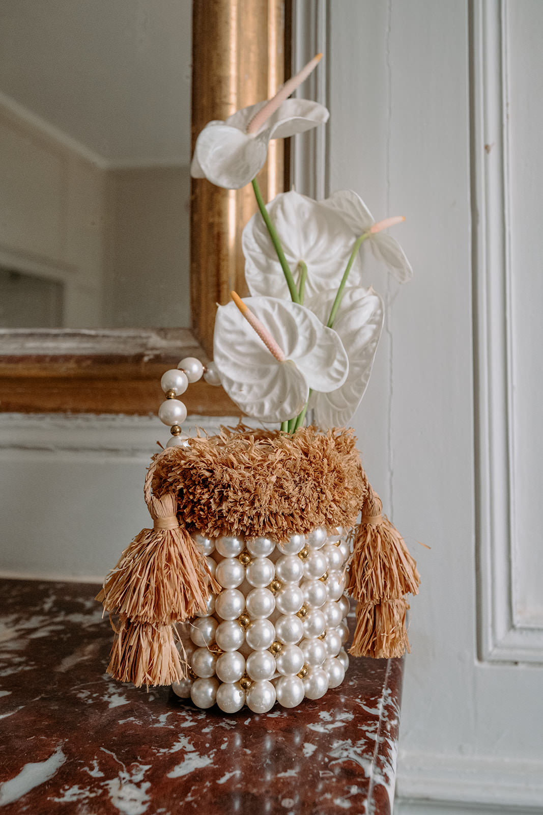 White anthurium flowers in a pearl and raffia vase