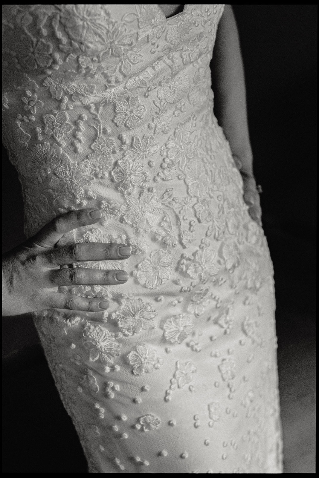 Black and white detail of a textured lace wedding dress