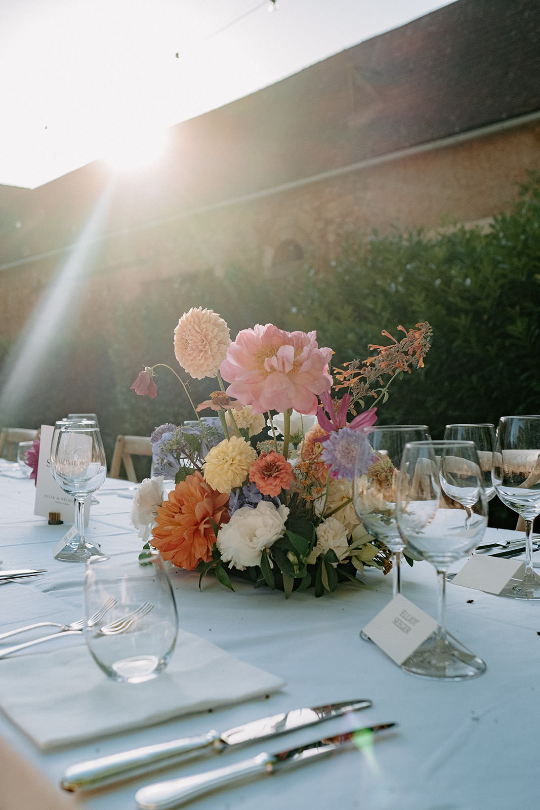 Wedding dinner table with colourful flowers in evening sunlight