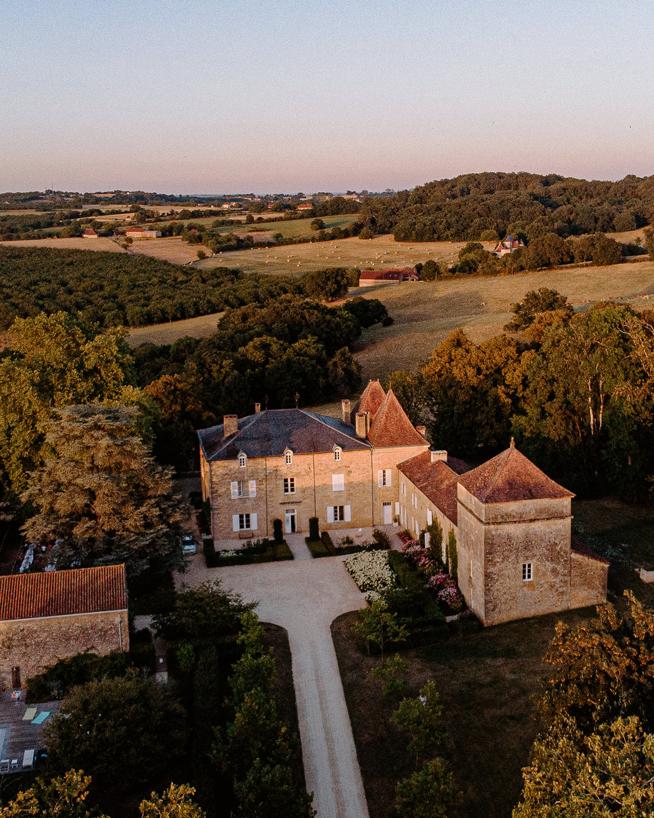 Aerial view of a château surrounded by countryside at sunset