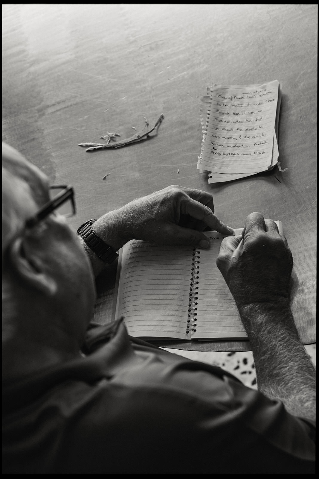 Black and white photo of a man writing a wedding speech by hand