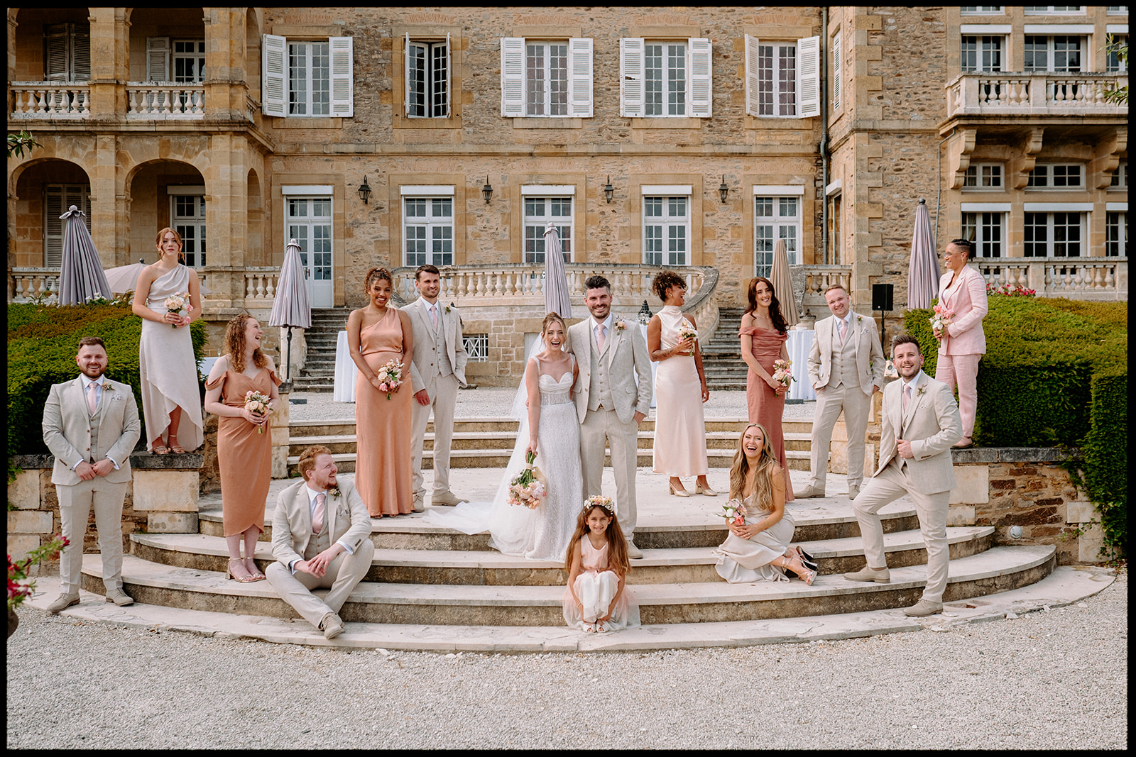 Wedding party posing on the steps of a château