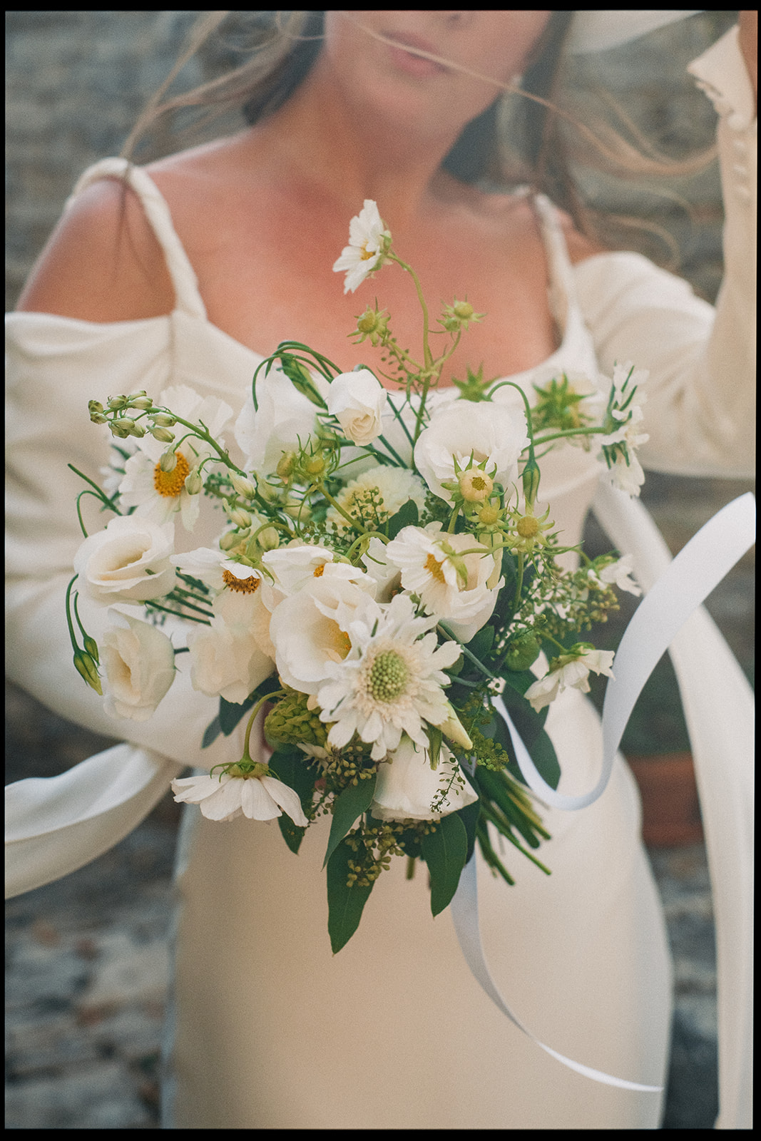 Bride holding a bouquet of white wildflowers, photographed on film