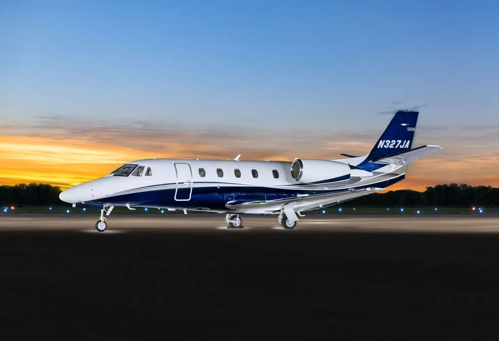 2024 Cessna Citation XLS Gen2 S/N 560-6360 - exterior of white and blue aircraft for sale, parked on tarmac against sunset, Mikolay Jet group logo