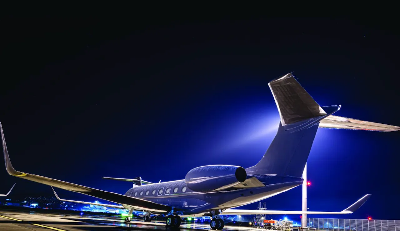 Photo of tail of private jet at nighttime - Private Flying