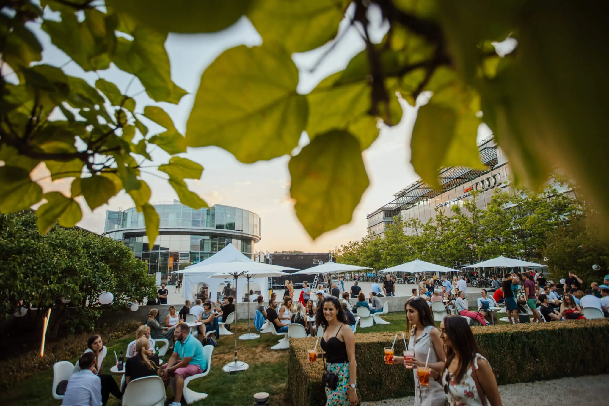 Eventfotograf München: gut gelaunte Damen flanieren mit kühlen Drinks über die Eventfläche