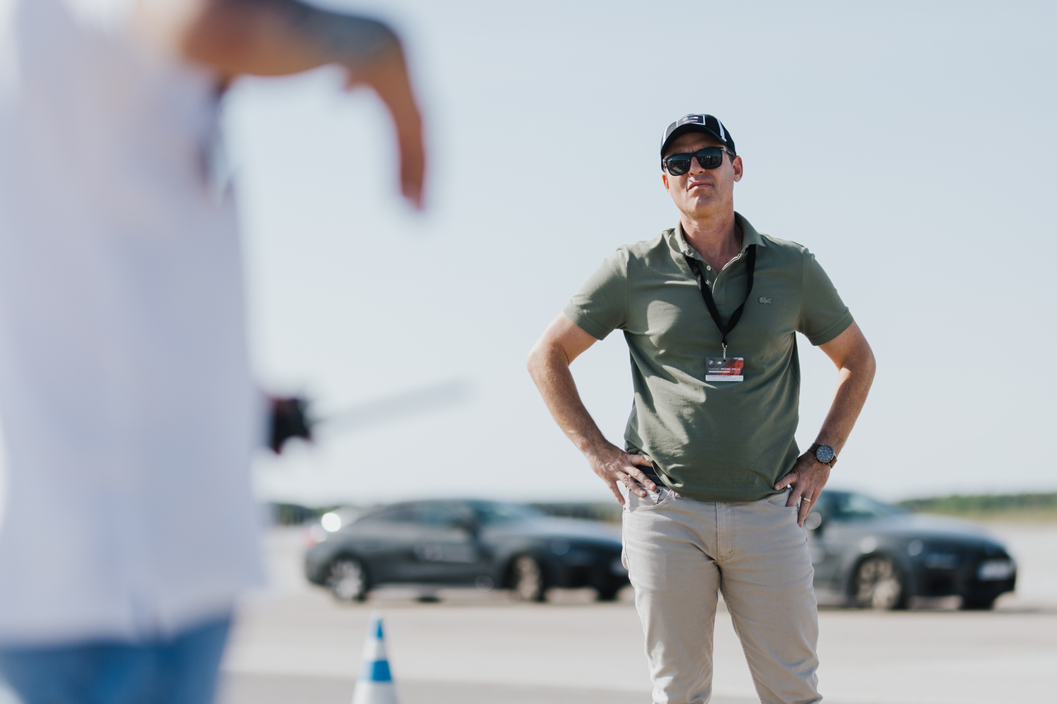 Briefing der BMW M Driving Experience – Fahrtrainer im Motorsport-Shirt erklärt Teilnehmern die Fahrtechnik auf der Teststrecke