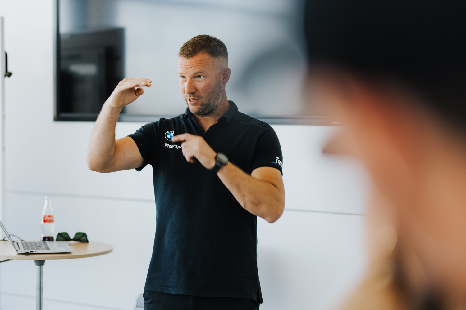 Ein Trainer erklärt gestikulierend Details beim Theorie-Teil eines Business-Workshops – lebendige Reportagefotografie für Unternehmen in München.