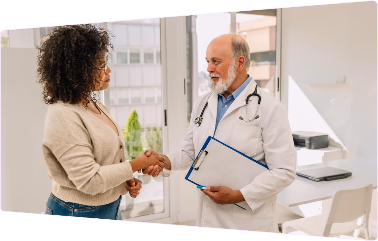 Médico apertando a mão de sua paciente no consultório.