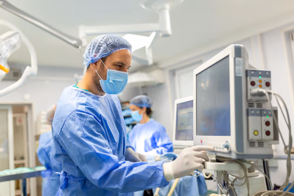Ventilador médico sendo monitorizado por um cirurgião anestesista usando monitor na sala de cirurgia