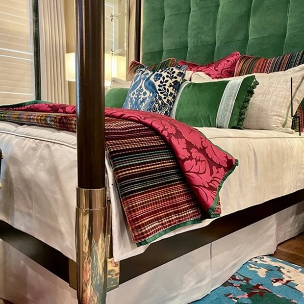 a bedroom filled with custom beddings, drapes and window treatments