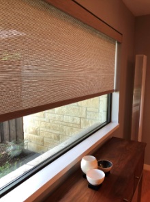 Textured roller window shades in Highland Park, TX, filtering natural light while maintaining privacy. These modern window shades help create a calm and comfortable living environment.