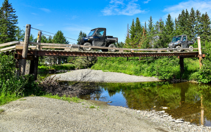 two side by sides crossing carter brook trails in the st john valley are typical new england atv trails with a big gravel bar and big views for family atv trips.