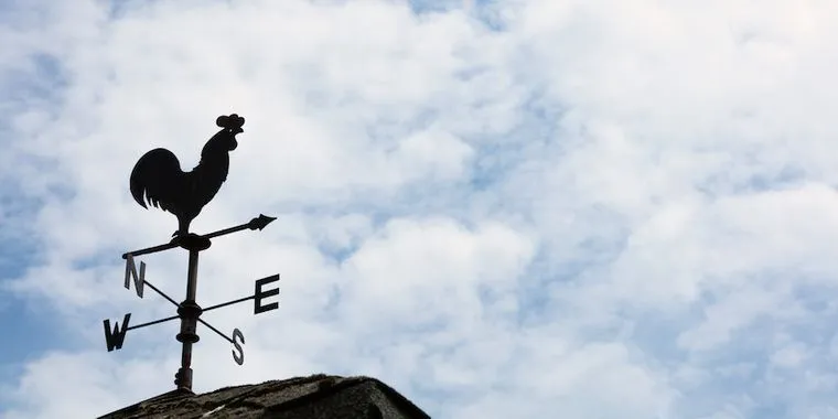An image of a rooster weathervane with a blue sky.