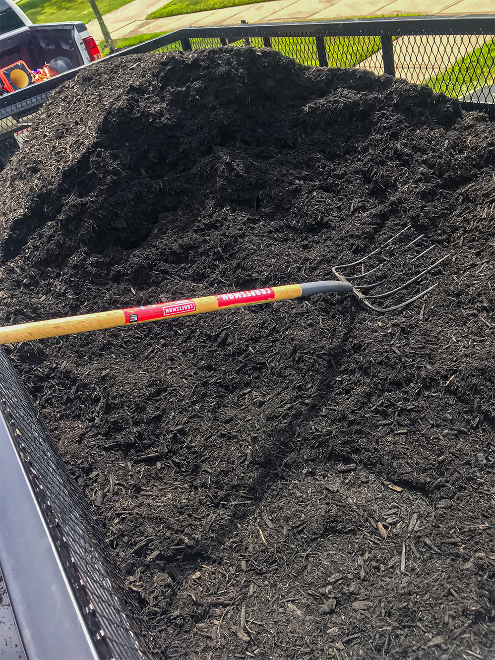 Neatly edged garden bed after professional mulching service
