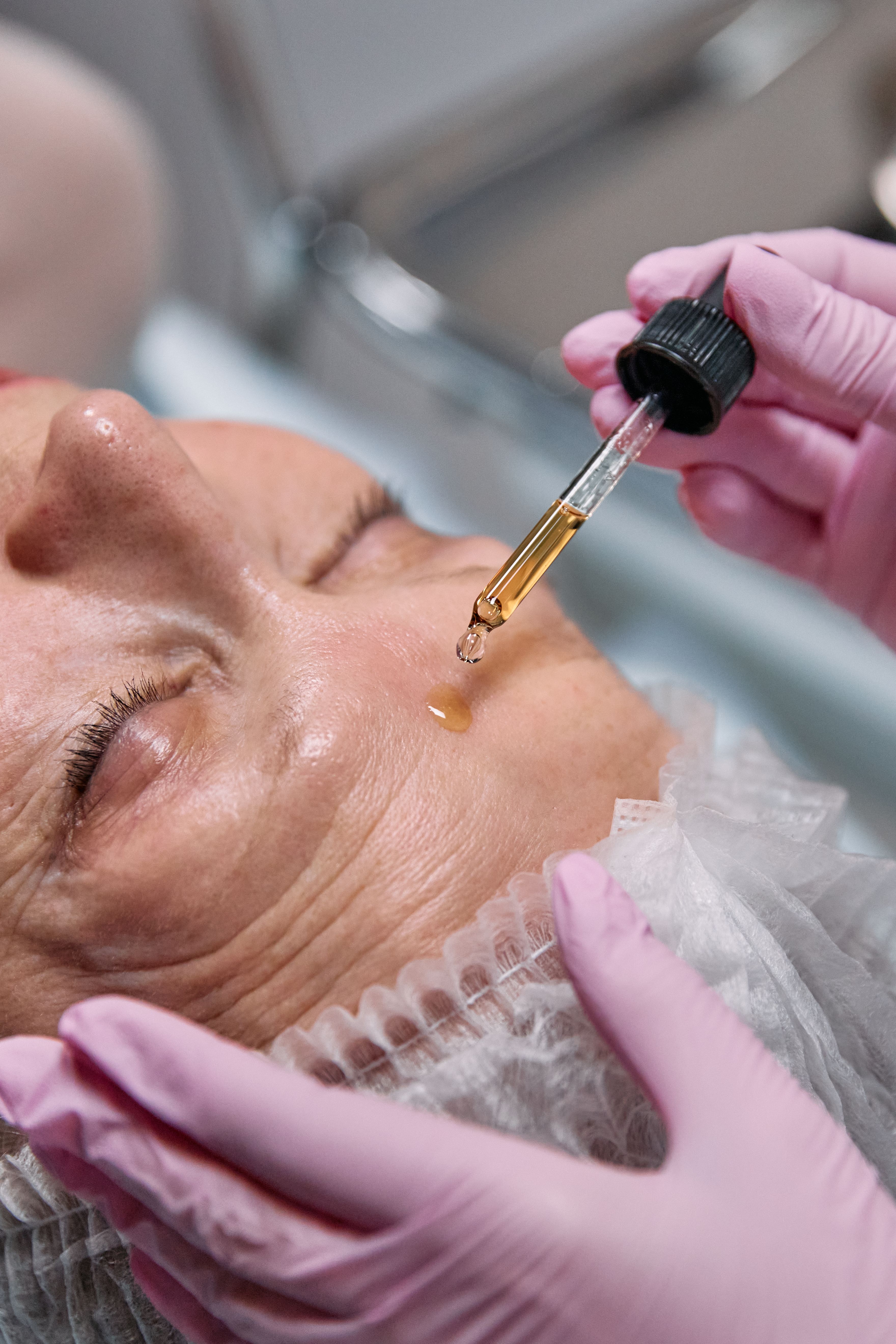 Dropper applying biostimulating serum to a client's skin at Kalos & Muse