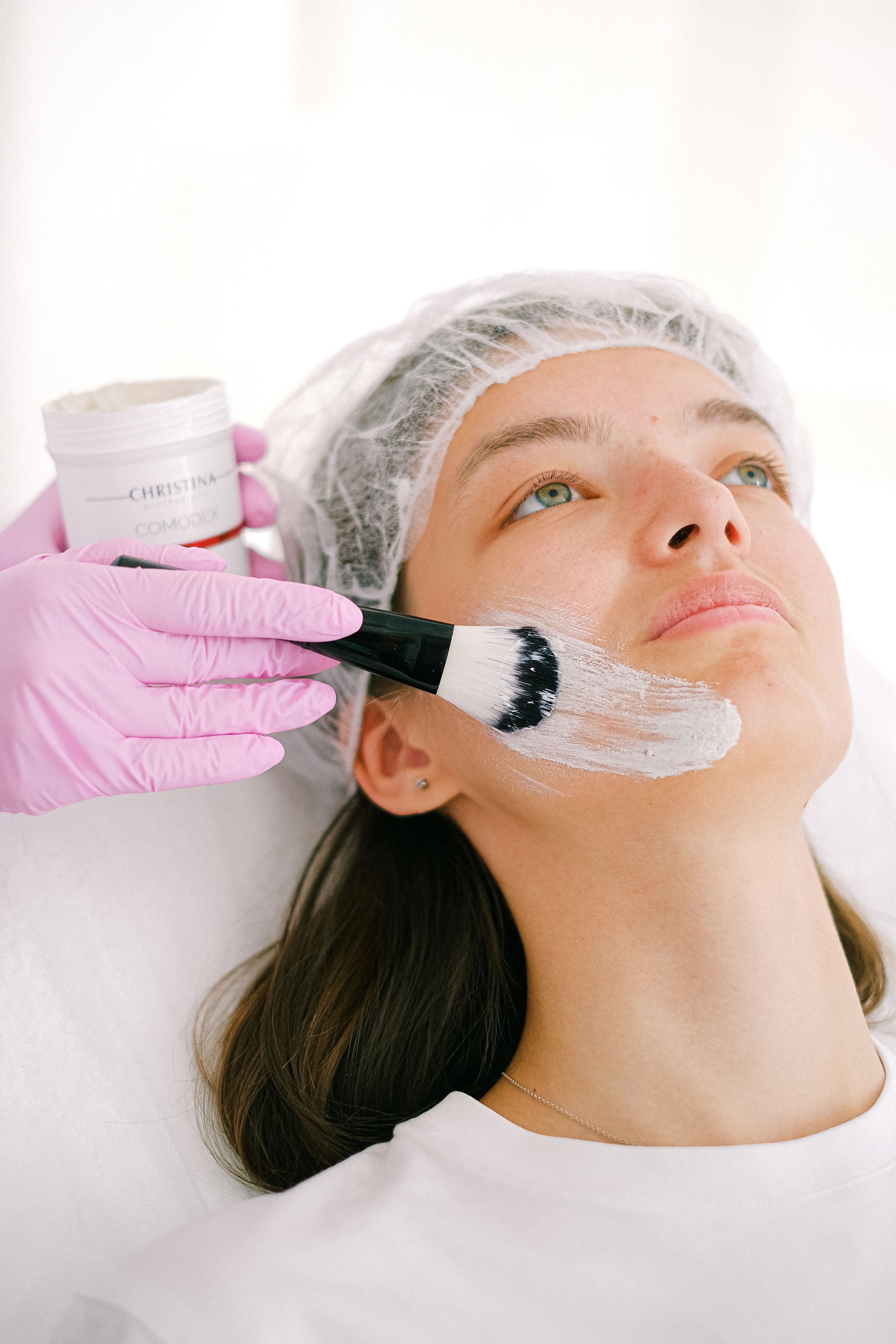 Esthetician applying a traditional chemical peel mask with a brush