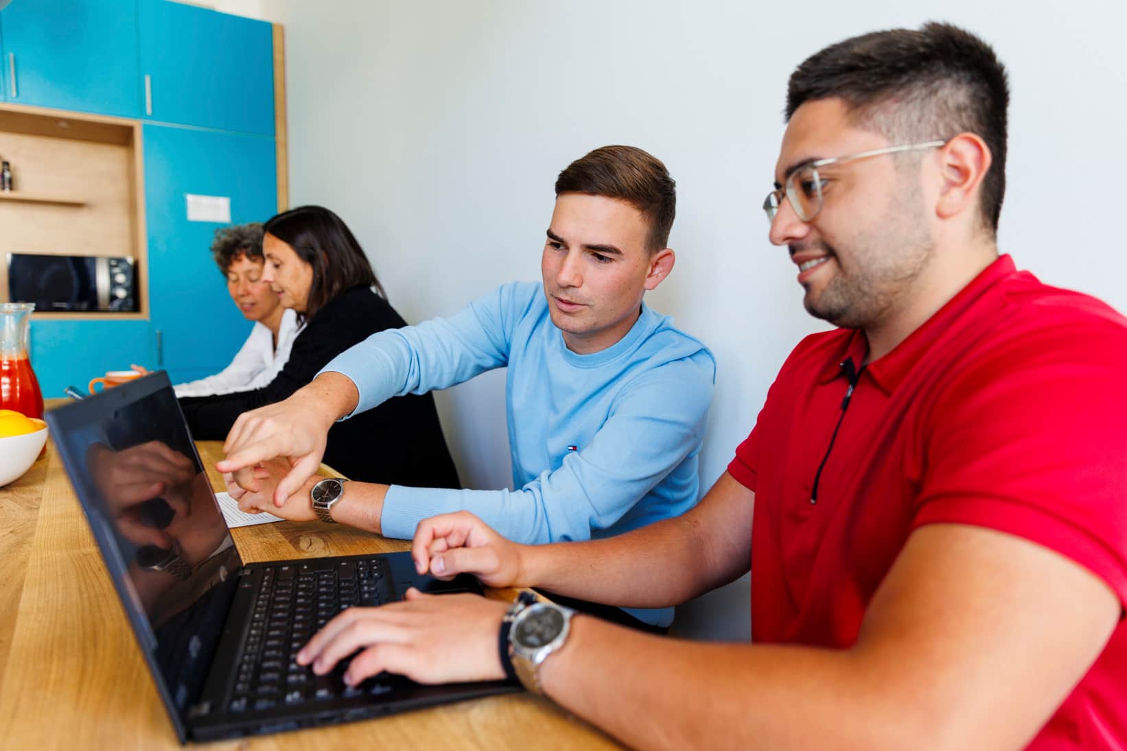 Interdisziplinäres Team von Kolleg:innen im Büro im Gespräch.