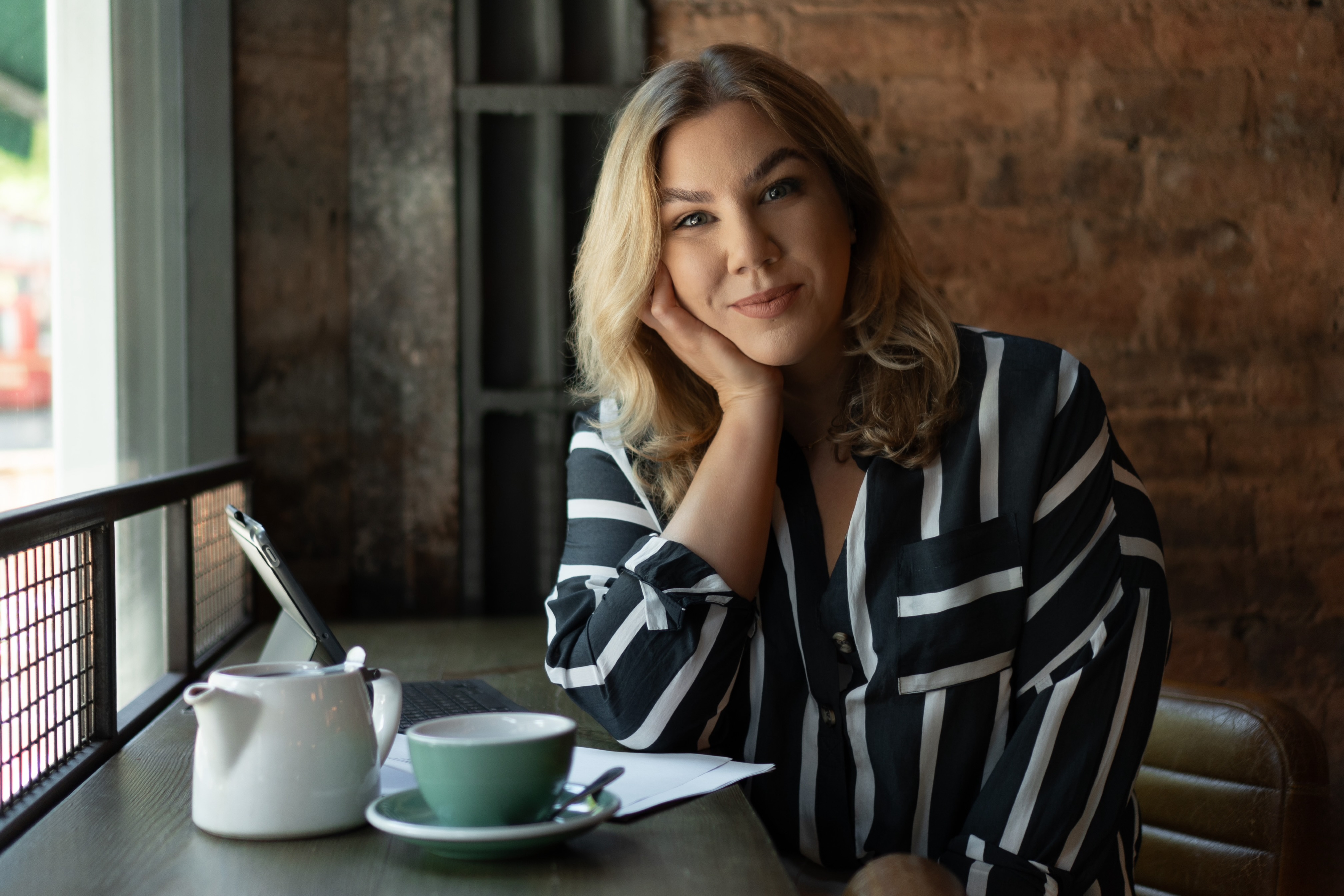 A photo of Cat the celebrant sitting in a coffee shop in Birmingham, West Midlands, ready to meet you for a coffee to talk about your wedding.