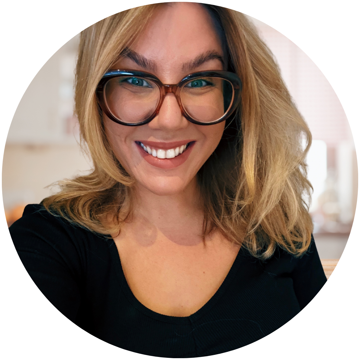 Cat the Celebrant smiling with brown glasses, blonde hair and a black top.