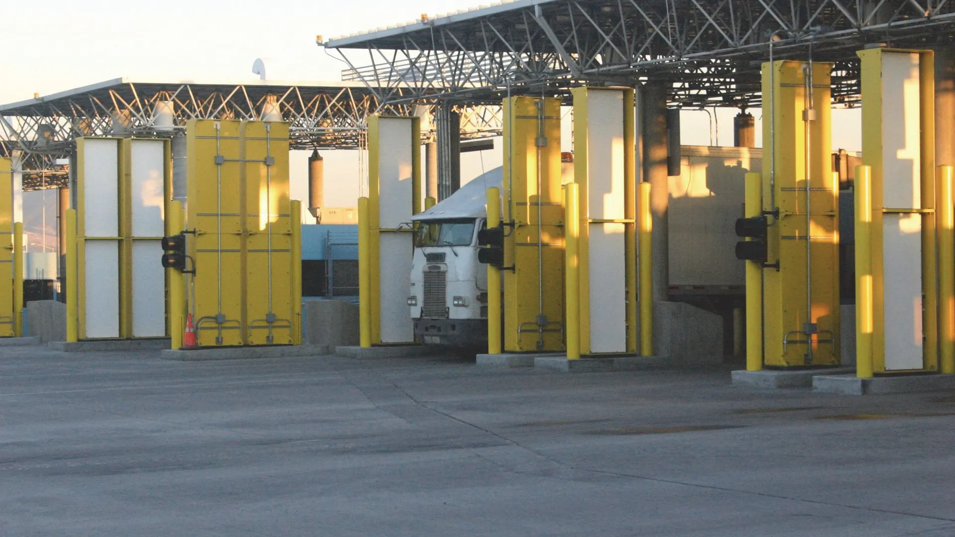 Two semi trucks driving through a border crossing