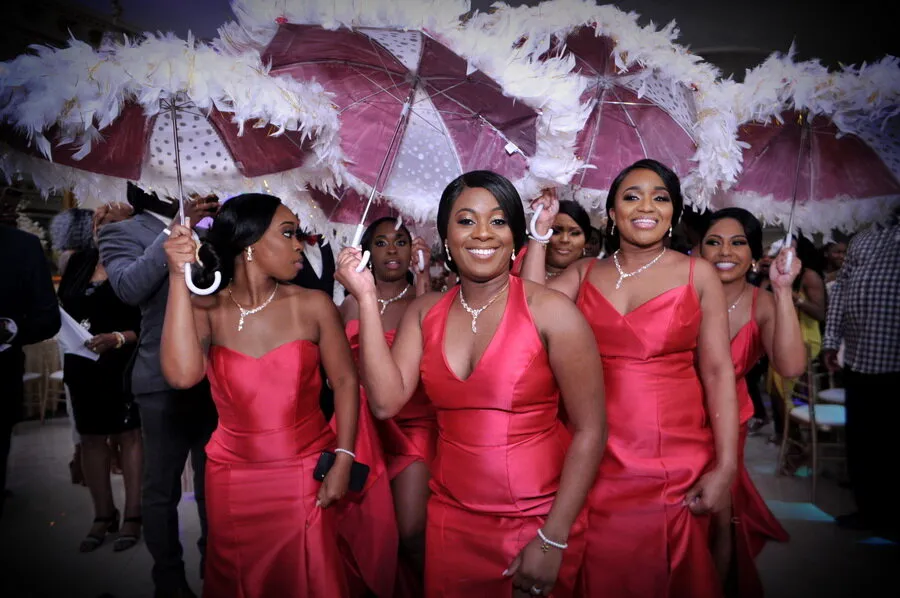 Three bridesmaids dancing with umbrellas.