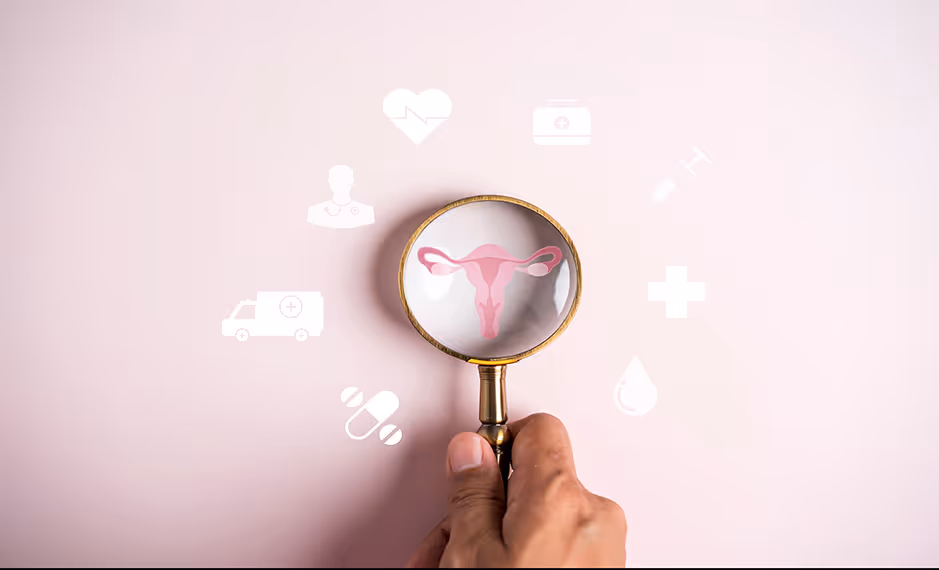 Hand holding a magnifying glass over a uterus illustration with medical icons on a pink background.