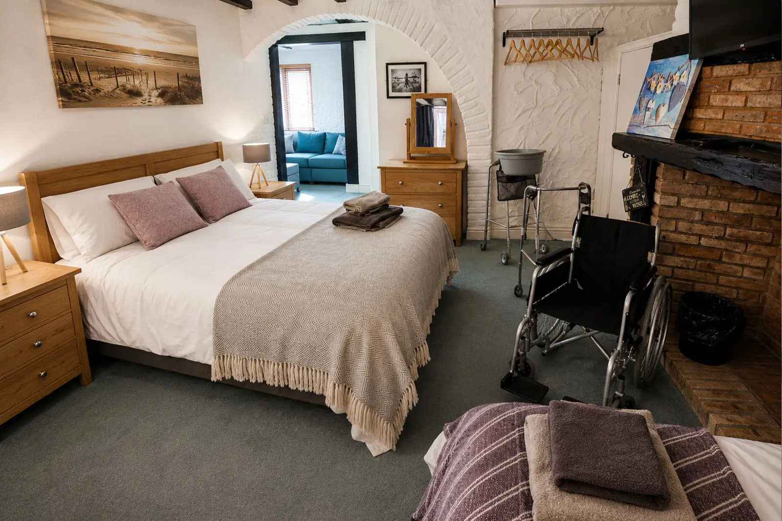 A double bedroom with an additional single bed and a wheelchair