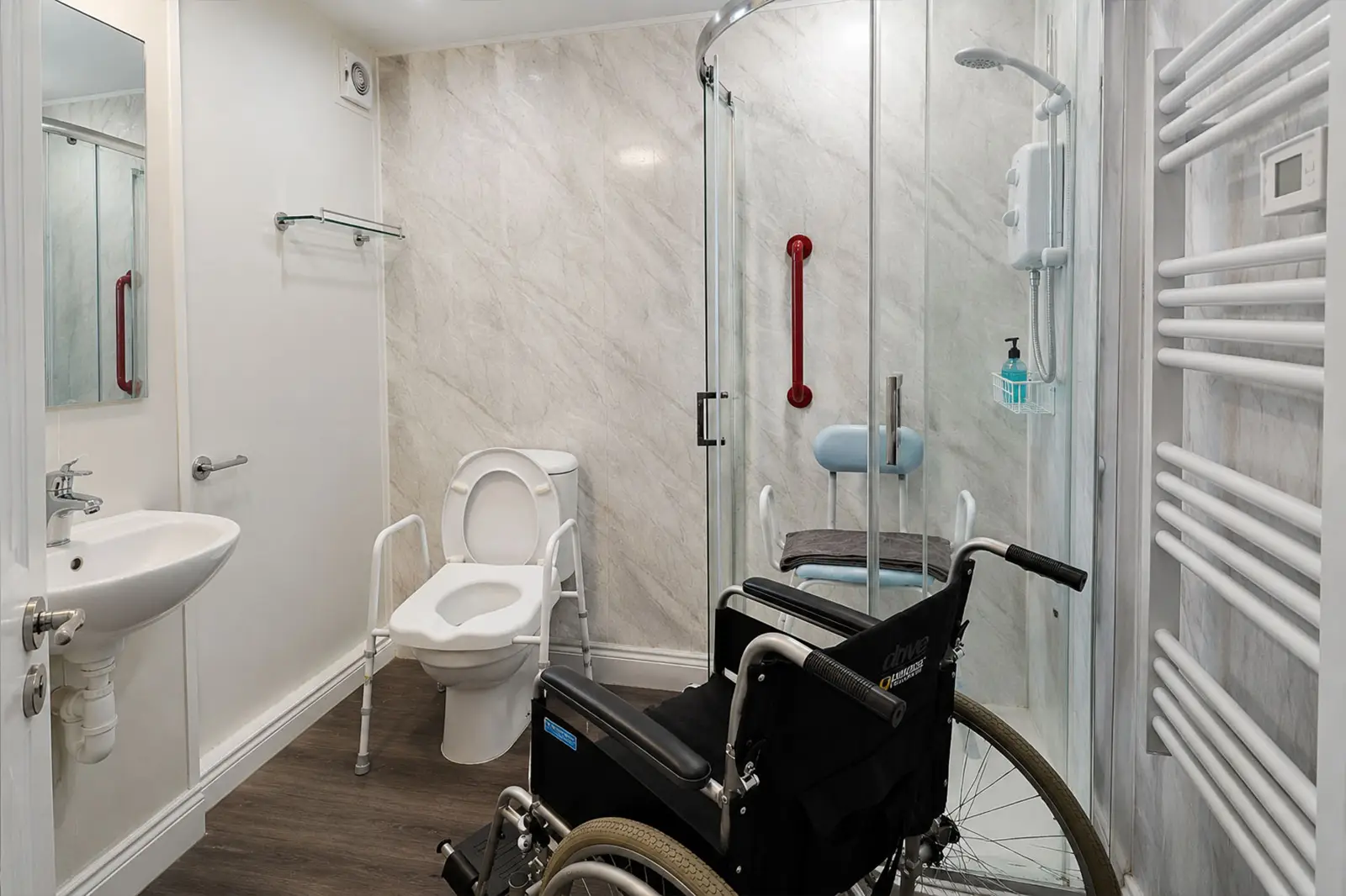A shower room with wheelchair in the foreground