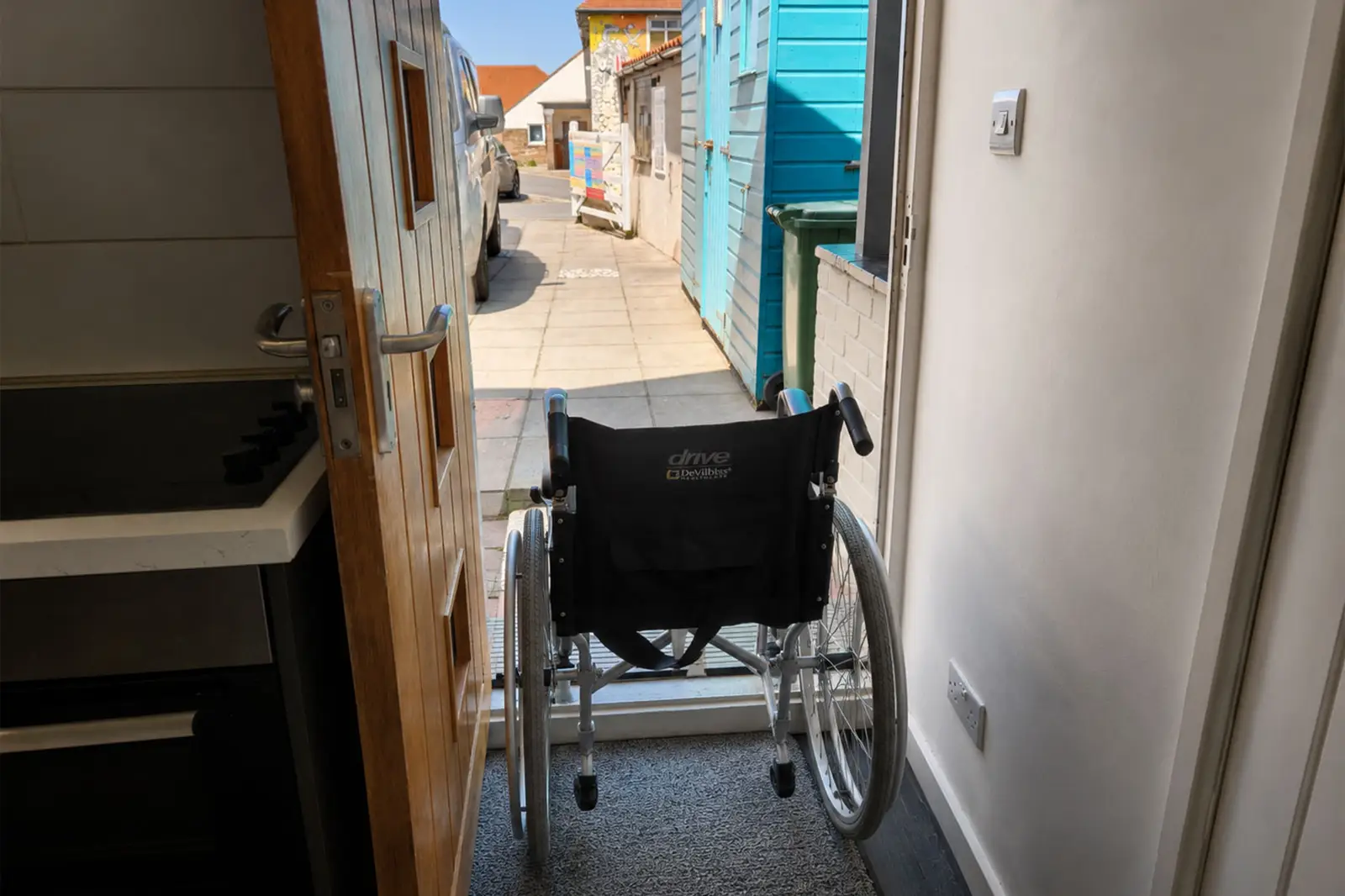 A doorway with a wheelchair looking out to a bright day